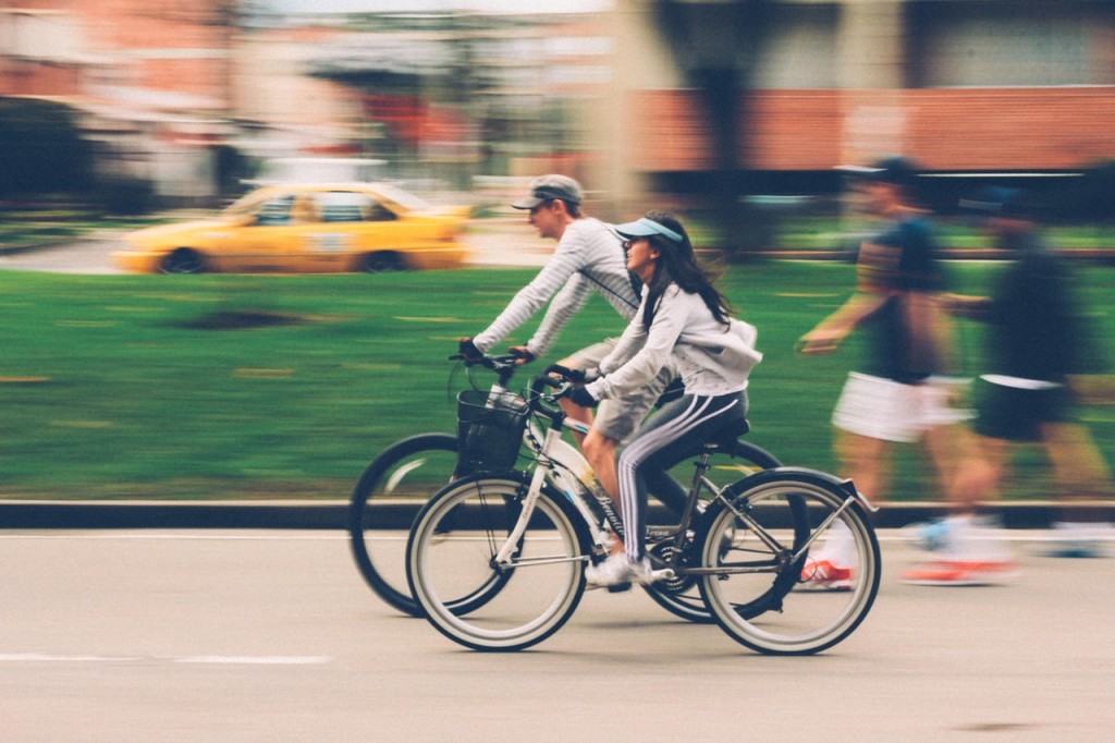 Couple riding bikes through the city park