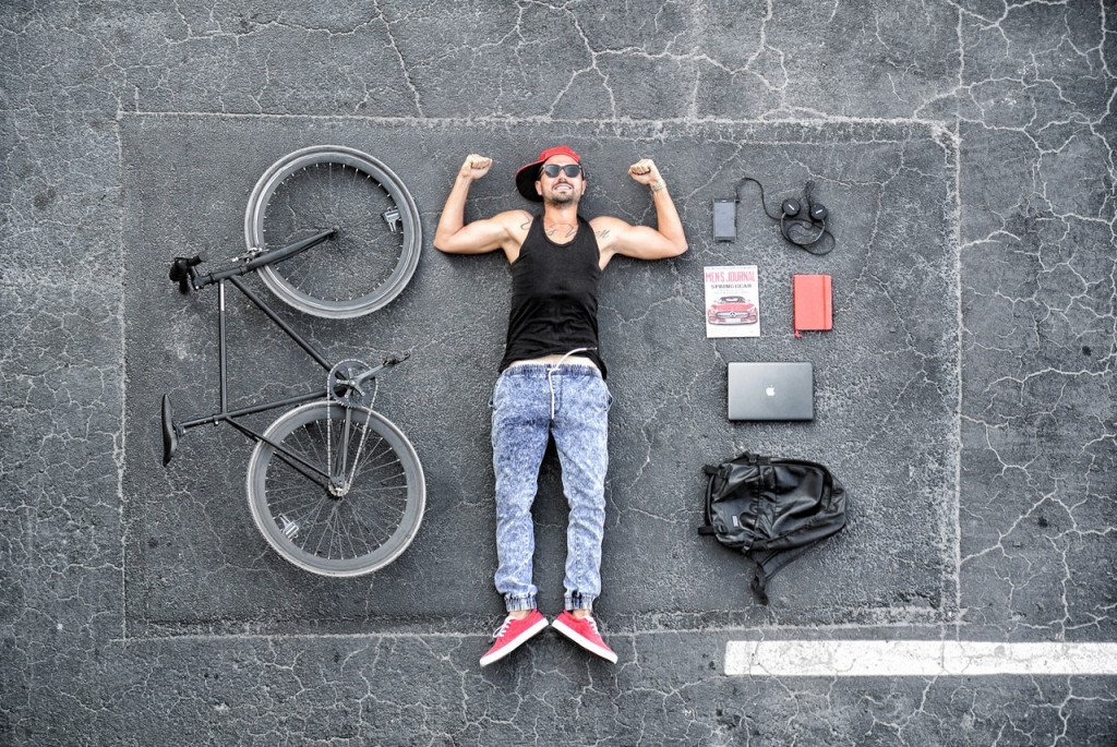 Man lying on the floor with bike to one side and bike accessories on the other side