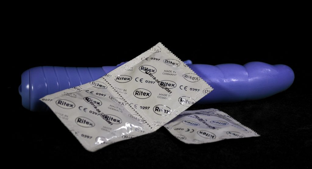 purple dildo and condoms . on top
