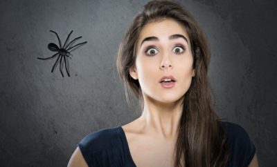 woman fearful of spider behind her, phobia
