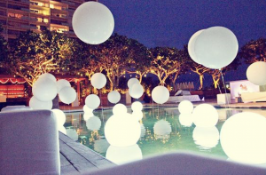 White balloons surrounding a pool at night