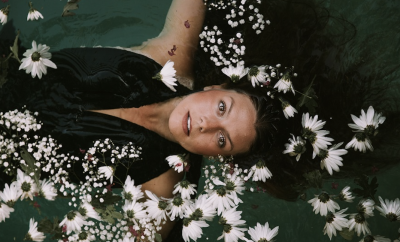 woman in clothes under water surrounded with flowers