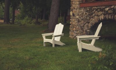 two outdoor white chairs in manicured lawn