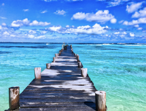 wooden walking bridge with blue ocean and sky