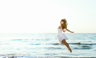 woman in white at beach flying