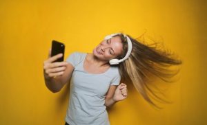 Woman taking a selfie with white headphones