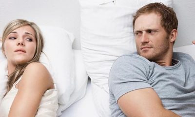 Couple with back to each other in bed