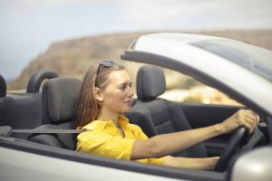 woman in yellow top driving a car