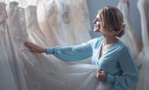 blond woman happily looking at a dress