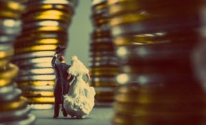Bride and groom standing in front of pile of coins