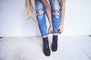 woman tucking her jeans into her boots