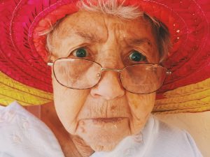 old lady wearing a red hat and glasses