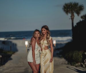 2 blond women, beach, night time