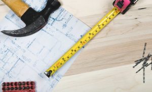 hammer, metric tape and a houe plan