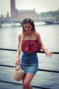 young woman leaning against a railing by a river