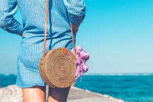 back shot of a woman with blue shirt at the beach