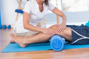 3 Benefits From Exercise Physiology-Trainer working with man on exercise mat in fitness studio