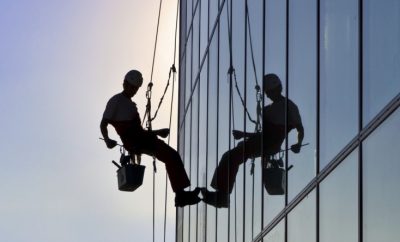 Window cleaner hanging by ropes