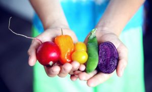 hand with coloured vegetables