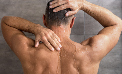 man showering rubbing back
