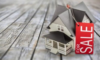 cardboard house and sale red sign