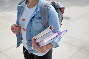 Student carrying her books and files on campus