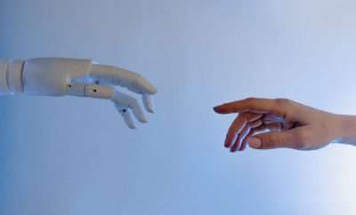A human hand touching an robot hand