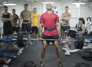 Men lifting weights with a crowd