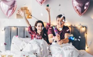 Couple in bed celebrating an occasion with ballons