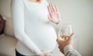 Pregnant woman refusing a glass of wine