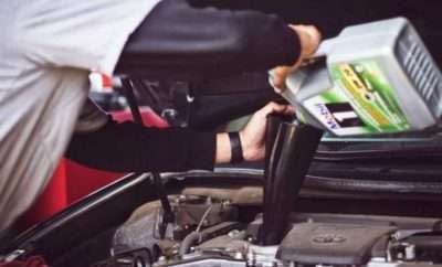 Mechanic putting oil in a car