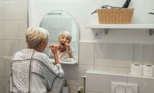Old woman cleaning her teeth; Oral Health