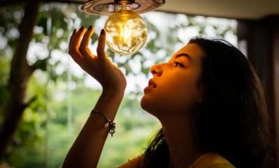 Woman looking cupping a lightbulb