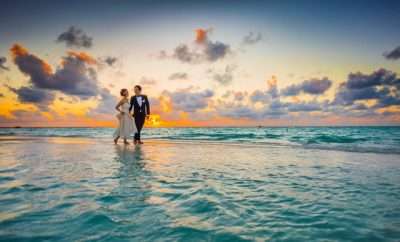 Newly wed couple walking on the beach
