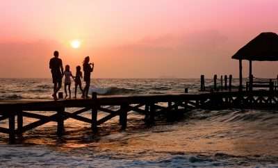 Family having a walk on the beach at dusk