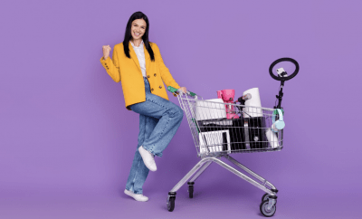 Woman in yellow jacket happily pushing a shopping trolly