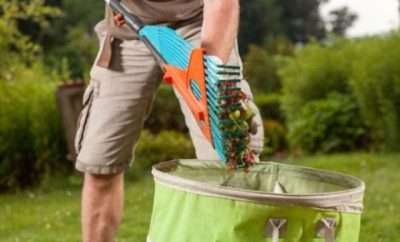 Man disposing of garden waste into a green bag