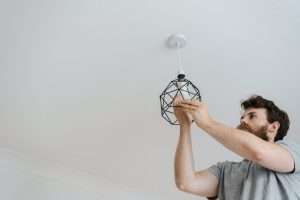 Man/ electrician changing a light bulb