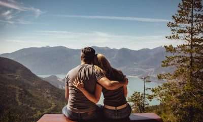 Couple sits and looks at mountain view