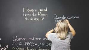 Child writing on the blackboard in two different languages