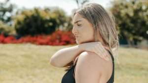 woman grabbing her shoulder with pain