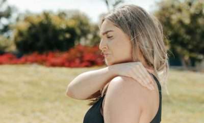 woman grabbing her shoulder with pain