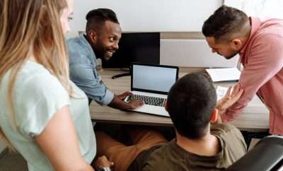 Group of people discussing work in front of laptop
