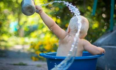 Baby splashing water in a bucket