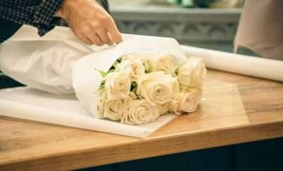 A bouquet of white roses being wrapped