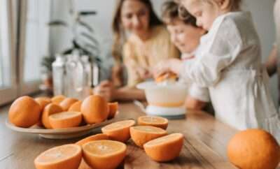 Kids with parents juicing some oranges