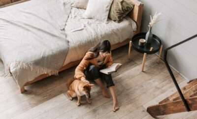 Woman sitting on her bedroom floor patting her dog