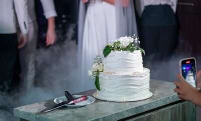 A wedding cake with white flowers as toppers