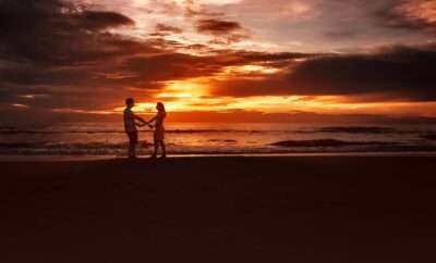 Couple holding hands walking on the beachh