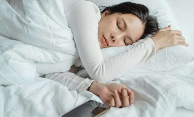 Woman peacefully sleeping in white sheets